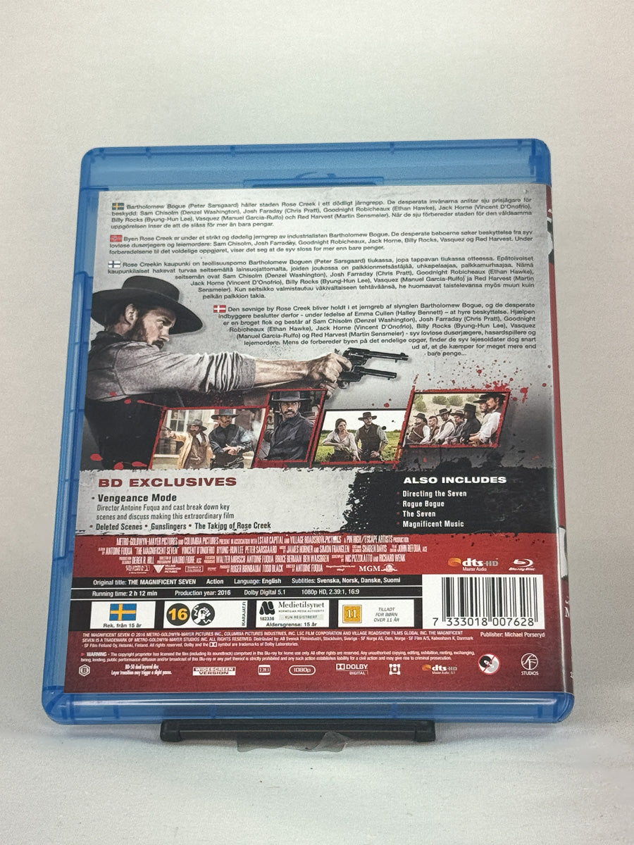 Bakside av Blu-ray-cover til The Magnificent Seven – nyinnspilling av westernklassikeren med stjernespækket rollebesetning, brukt Blu-ray hos Brukbar Film.
