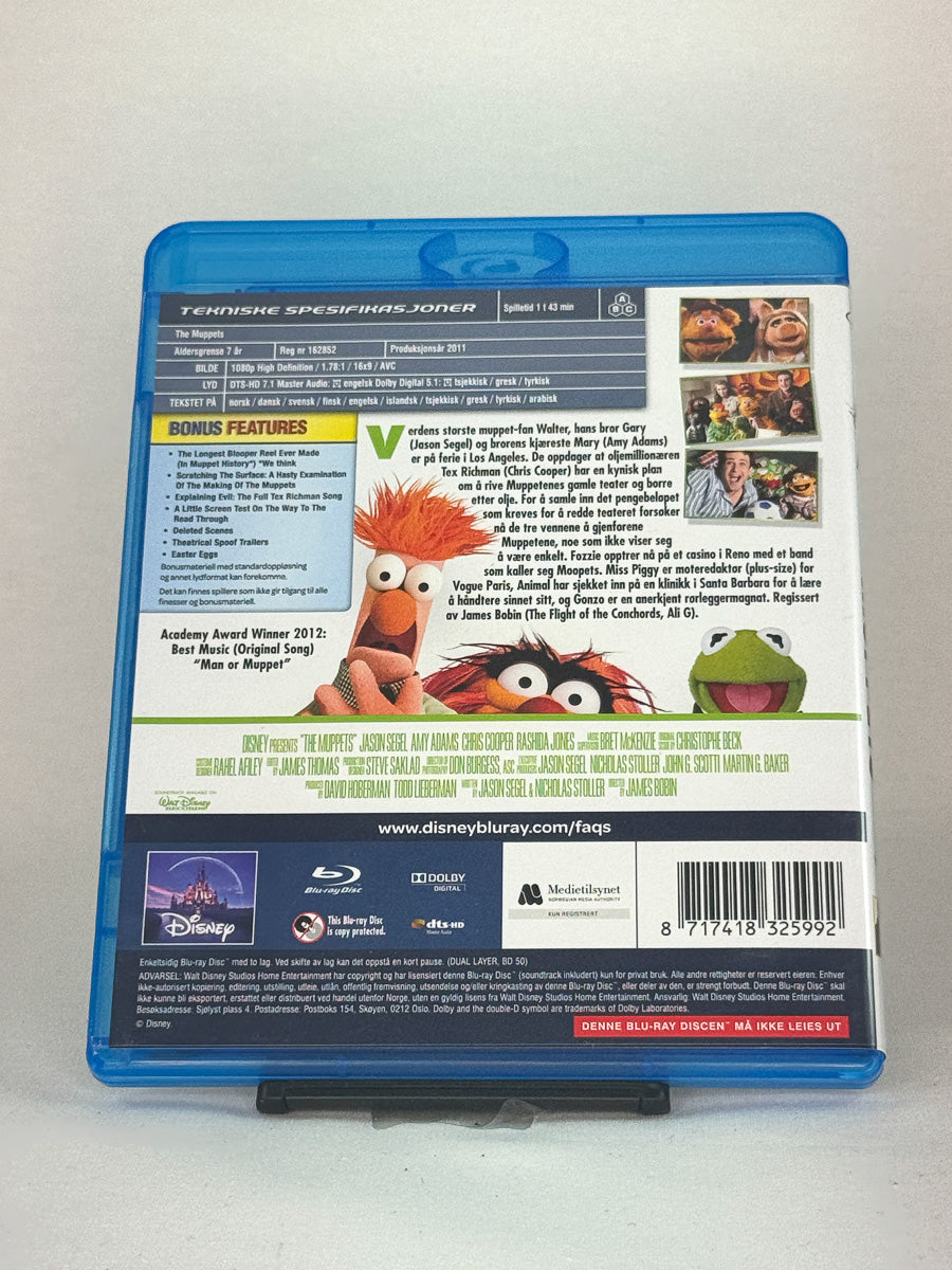 Bakside av Blu-ray-cover til The Muppets – fargerik og musikalsk familiefilm med klassiske Muppet-figurer, brukt Blu-ray hos Brukbar Film.