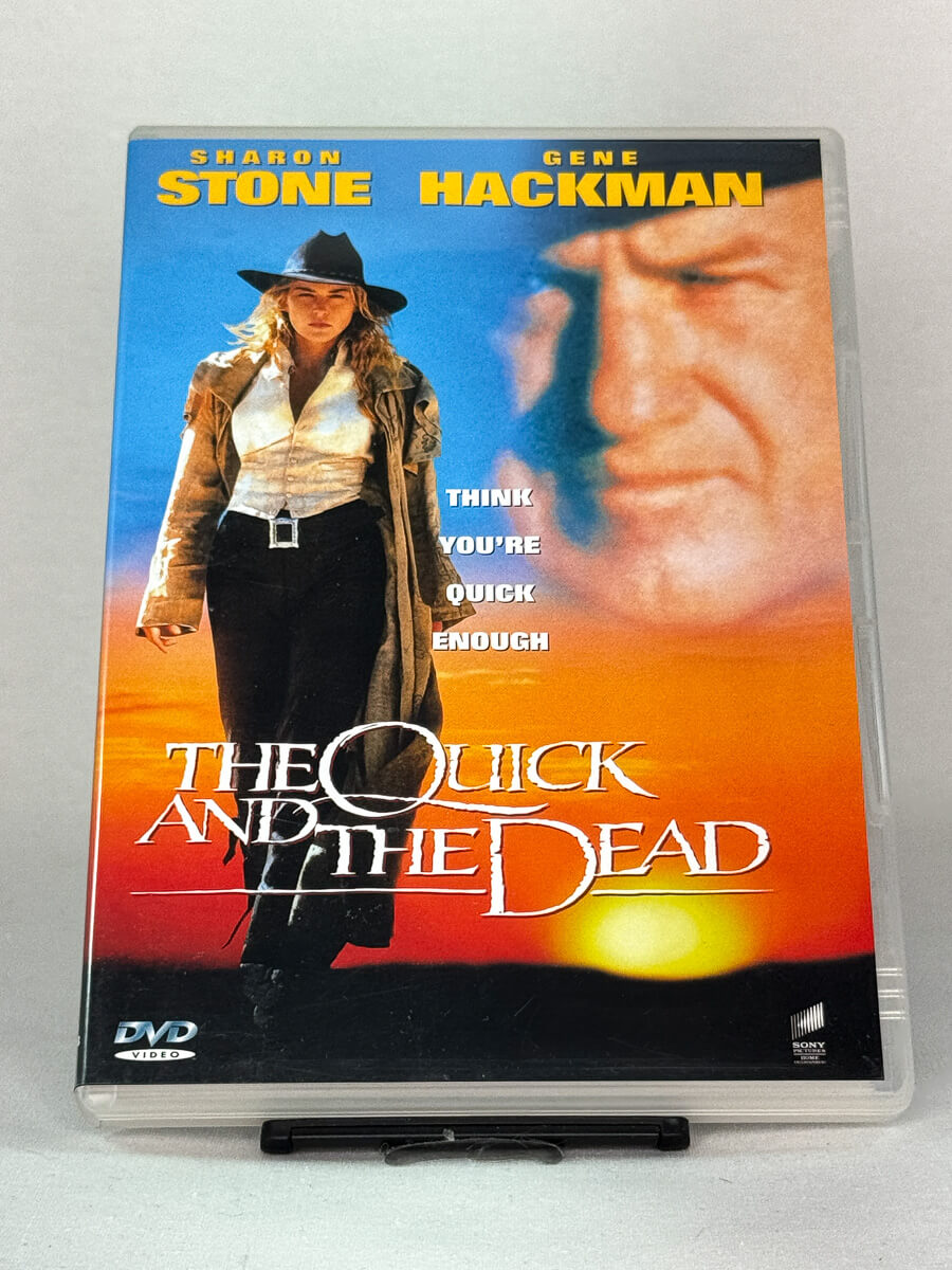 Forside av DVD-cover til The Quick and the Dead med Sharon Stone og Gene Hackman – actionfylt westernfilm regissert av Sam Raimi, brukt DVD hos Brukbar Film.