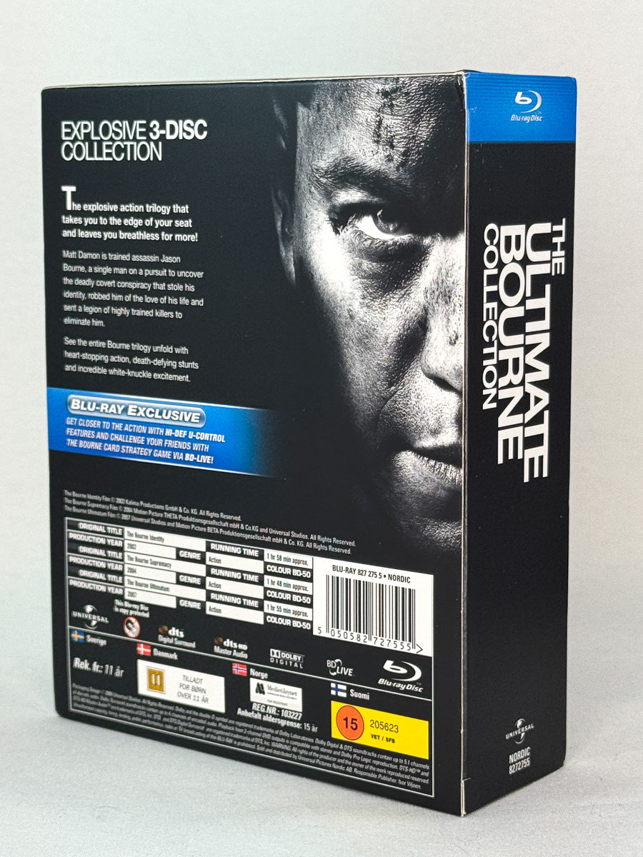 Bakside av Blu-ray-cover til The Ultimate Bourne Collection – actiontrilogi regissert av Doug Liman og Paul Greengrass, intens spionserie fra Universal, brukt Blu-ray hos Brukbar Film.