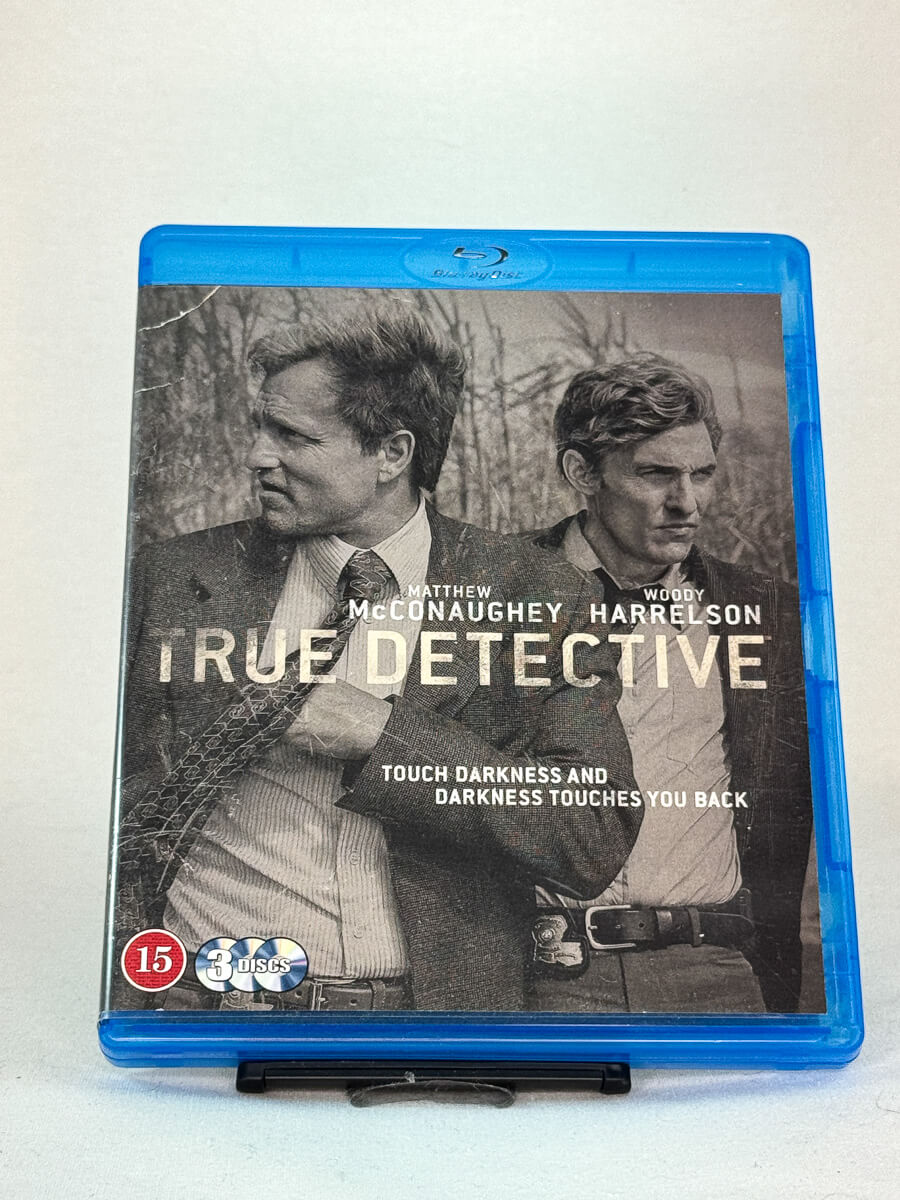 Forside av True Detective: Season 1 på Blu-ray – stilfullt brukt filmcover med Matthew McConaughey og Woody Harrelson, hos Brukbar Film.
