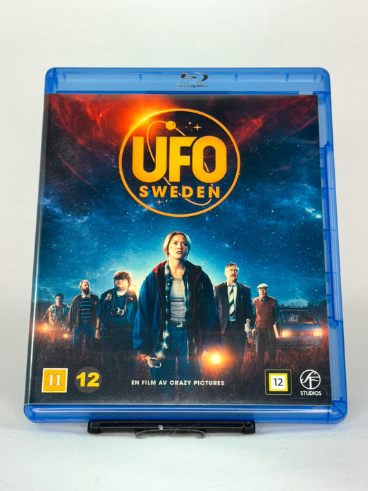 Forside av Blu-ray-cover til UFO Sweden – svensk sci-fi-eventyr fra Crazy Pictures med mystikk, spenning og hjertelag, brukt Blu-ray tilgjengelig hos Brukbar Film.