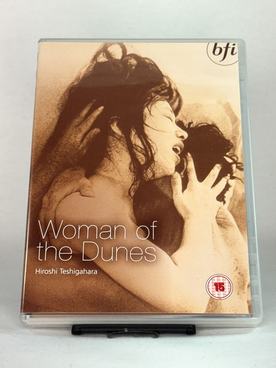 Forside av DVD-cover til Woman of the Dunes – japansk mesterverk av Hiroshi Teshigahara, poetisk og klaustrofobisk drama, brukt DVD hos Brukbar Film.