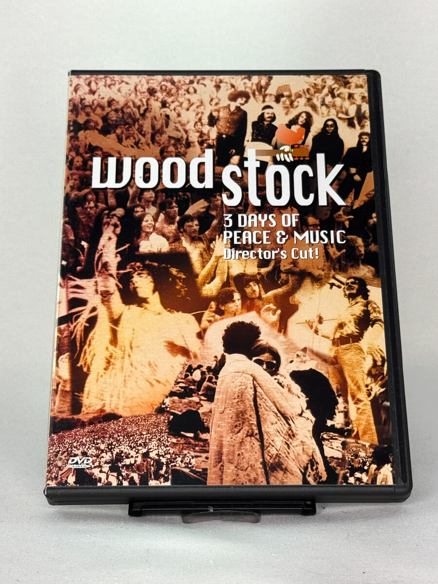 Forside av DVD-cover til Woodstock: 3 Days of Peace & Music – dokumentar om den legendariske festivalen i 1969, brukt DVD hos Brukbar Film.